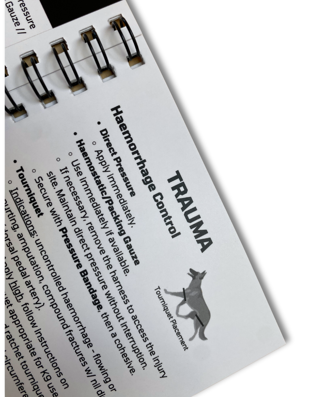 Open dog first aid book showing management of trauma.