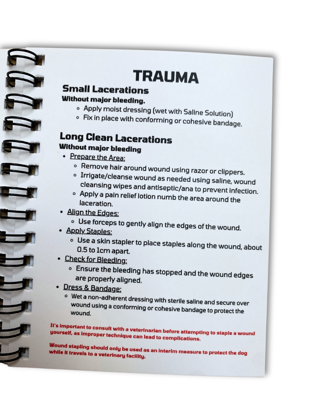 Open dog first aid book showing management of trauma.