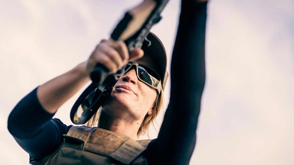 Woman holding rifle wearing ballistic sunglasses