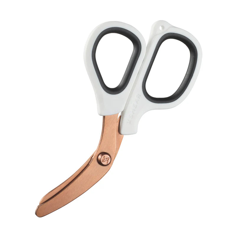 A pair of XShear Mini Trauma Shears with white handles and rose gold curved blades.