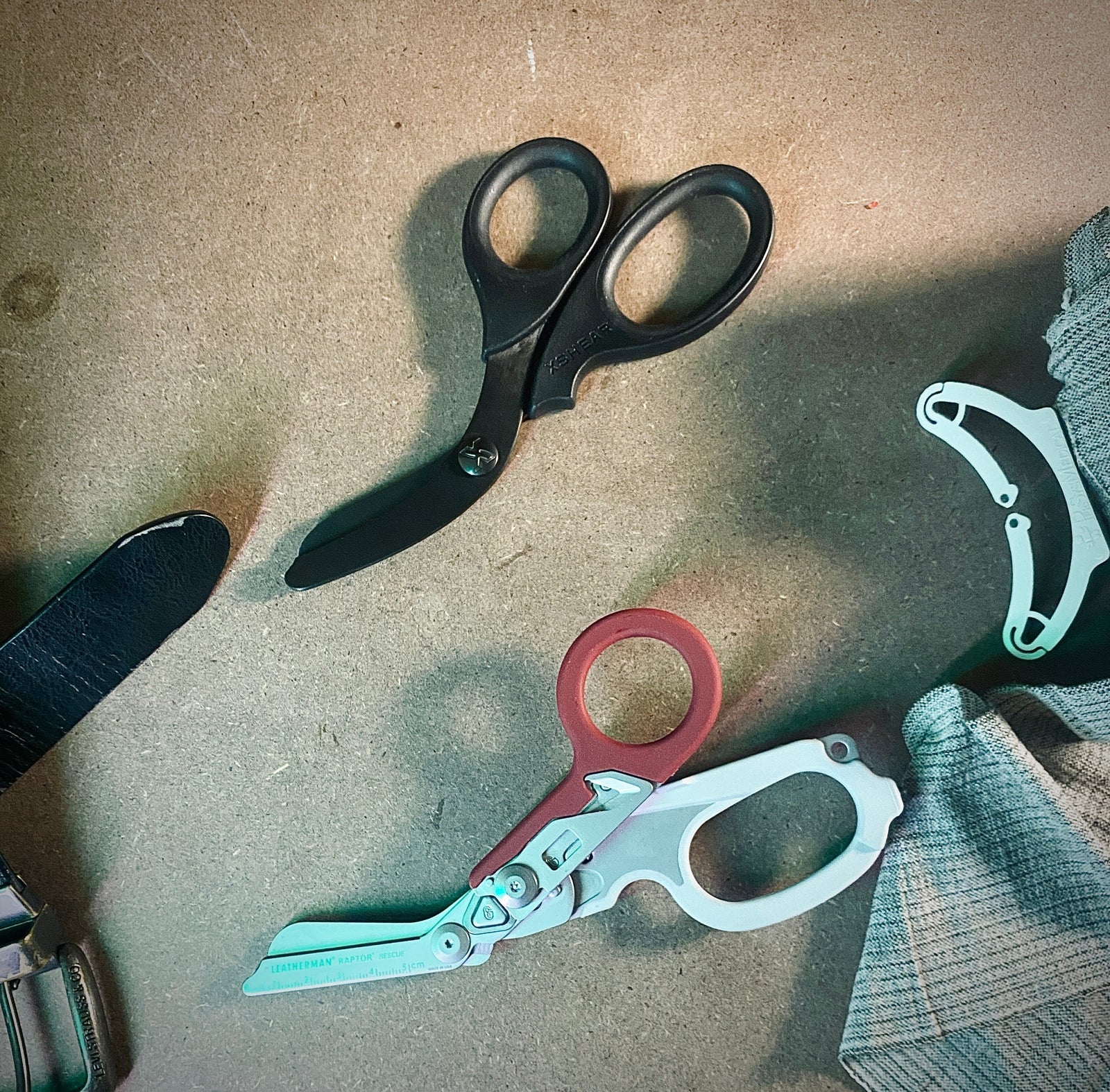 Image of XShears and Leatherman raptor trauma shears side by side on a wooden surface