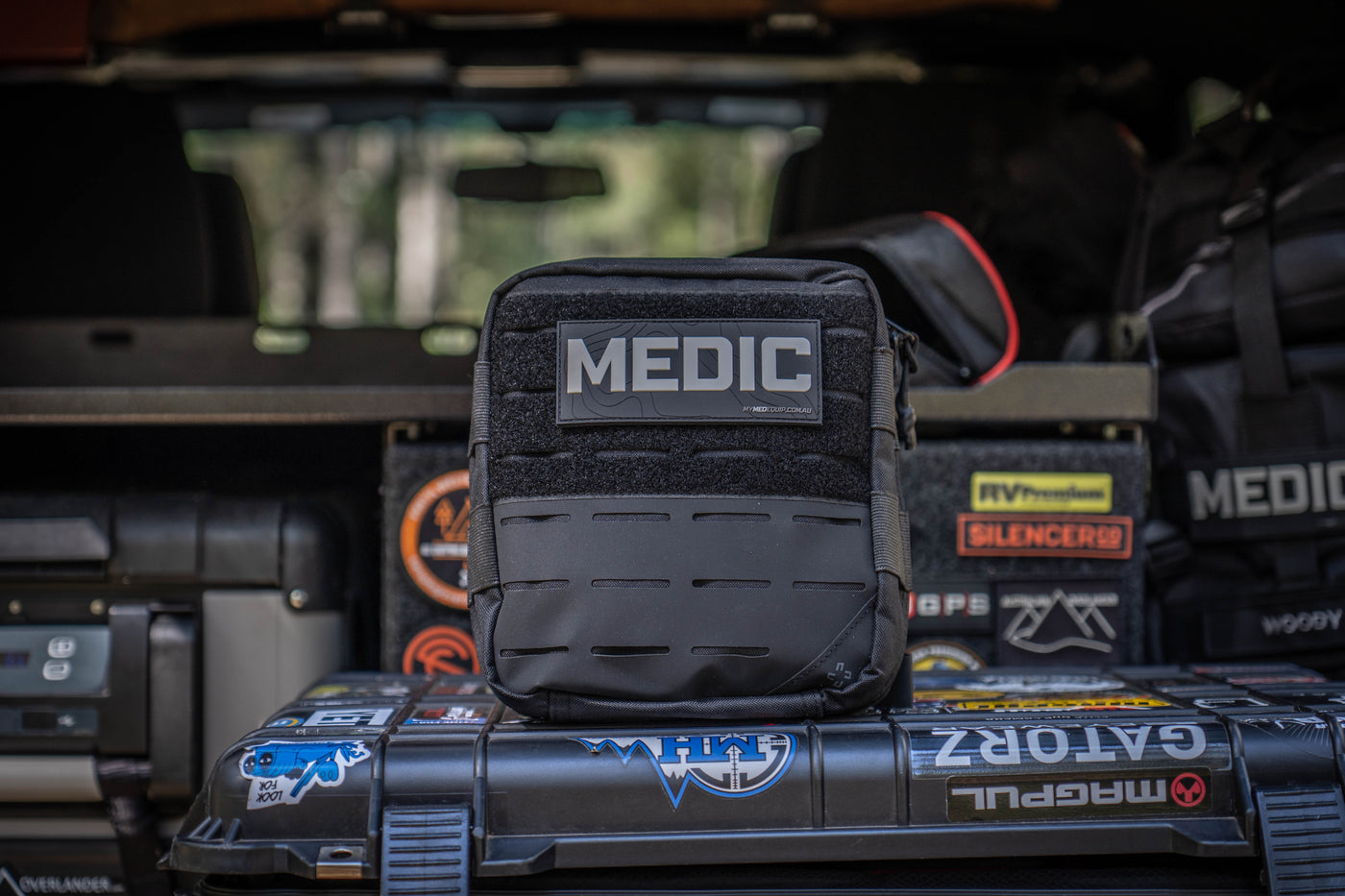 Black Tactical Medic Kit sitting in boot of response vehicle. Pouch has lasercut molle and a velcro front panel.