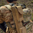 Soldier carrying EVAC Sleeve mounted to camouflage backpack outdoors